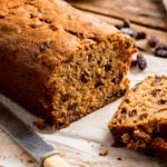 Close up of a fruit tea loaf that has been sliced on a wooden table.