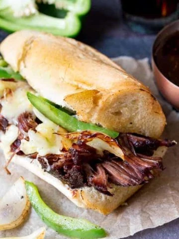 Slow-cooked brisket dip sandwich with peppers, onion and cheddar. Flavour packed and delicious!