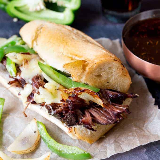 Slow-cooked brisket dip sandwich with peppers, onion and cheddar. Flavour packed and delicious!
