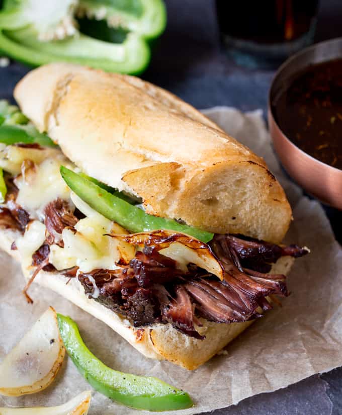 Slow-cooked brisket dip sandwich with peppers, onion and cheddar. Flavour packed and delicious!