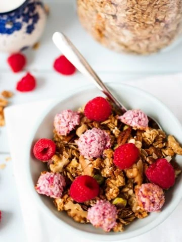 Crunchy, coconut oil granola topped with super-quick, fresh raspberry macaroons.