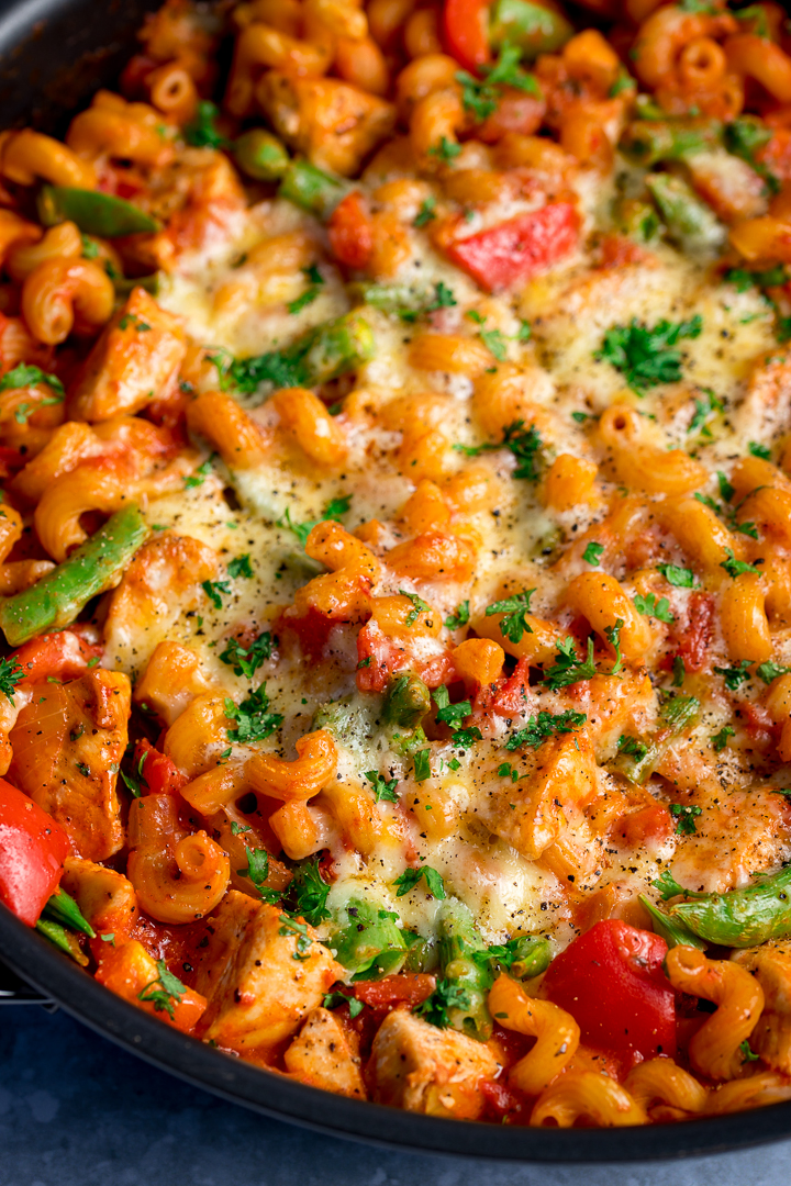 Close up of cheesy tomato chicken pasta in a pan