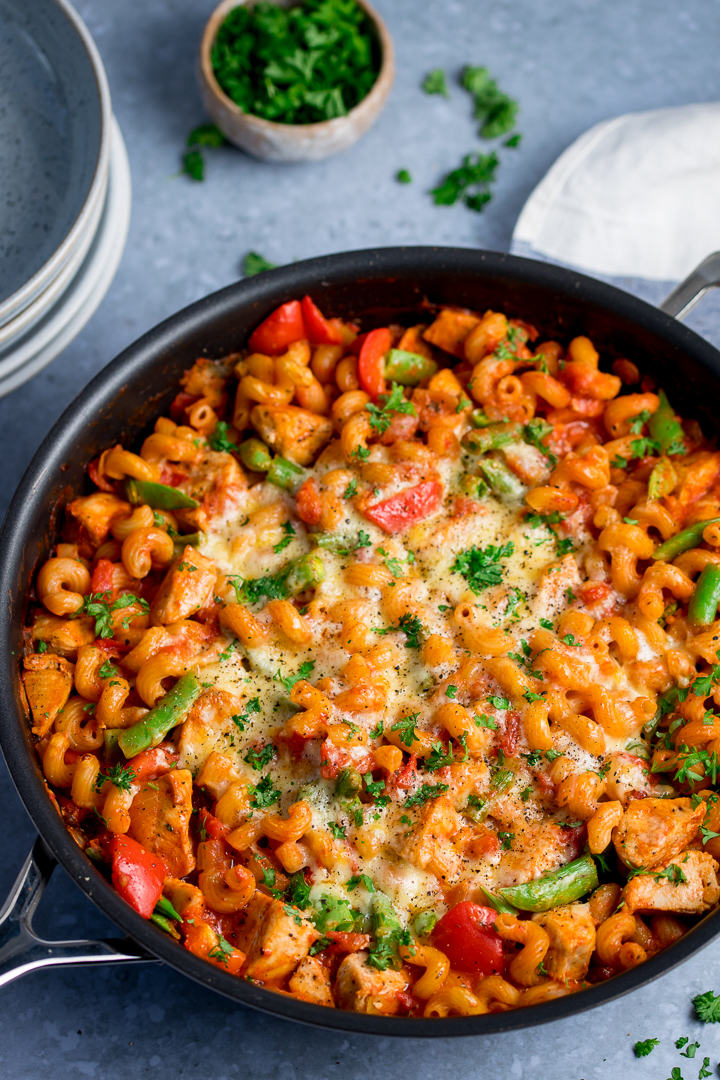 One pot chicken pasta in a pan on light blue background