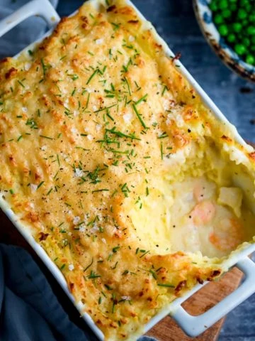 Fish pie with mashed potato in a white rectangular dish - scoop taken out