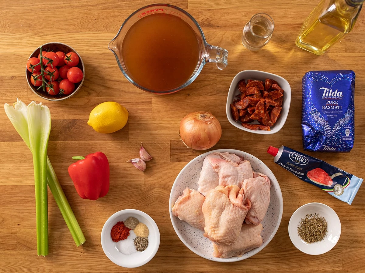 Ingredients for Spanish chicken and rice on a wooden table