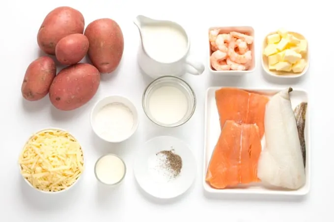 Ingredients for fish pie on a white board