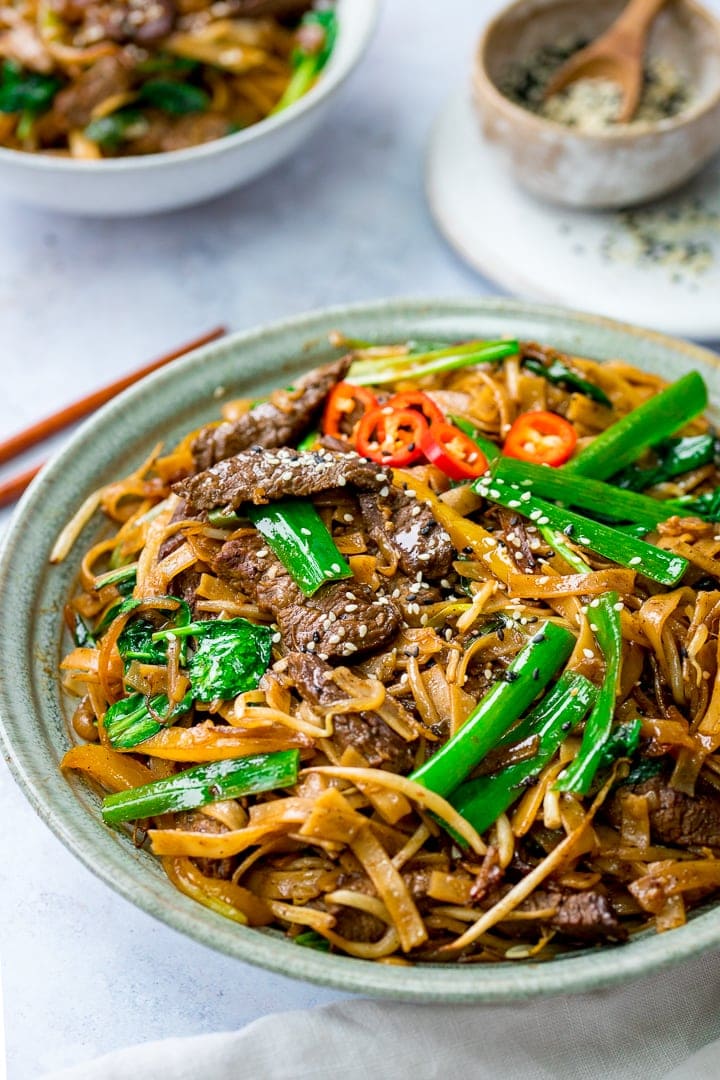 Light bowl filled with Beef Chow Fun on a light background