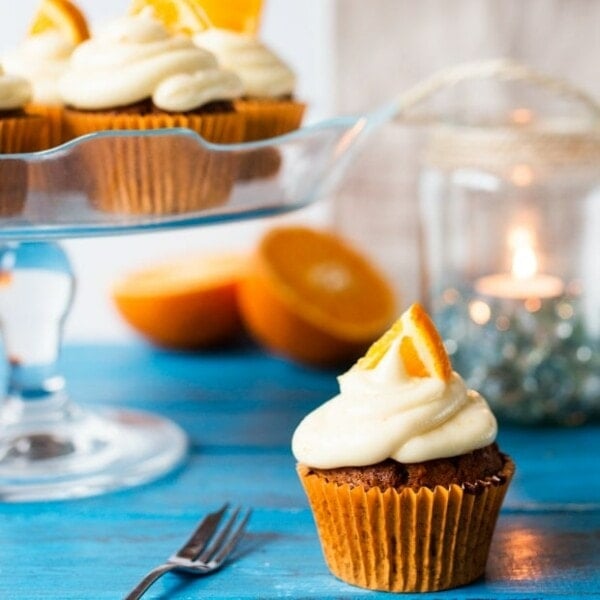 Moist and fluffy carrot & orange cupcakes with a hint of spice and lots of juicy raisins. All topped off with a zesty cream cheese frosting and orange wedges.