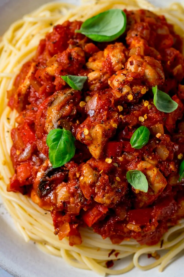 Overhead of chicken and red pepper sauce on top of spaghetti