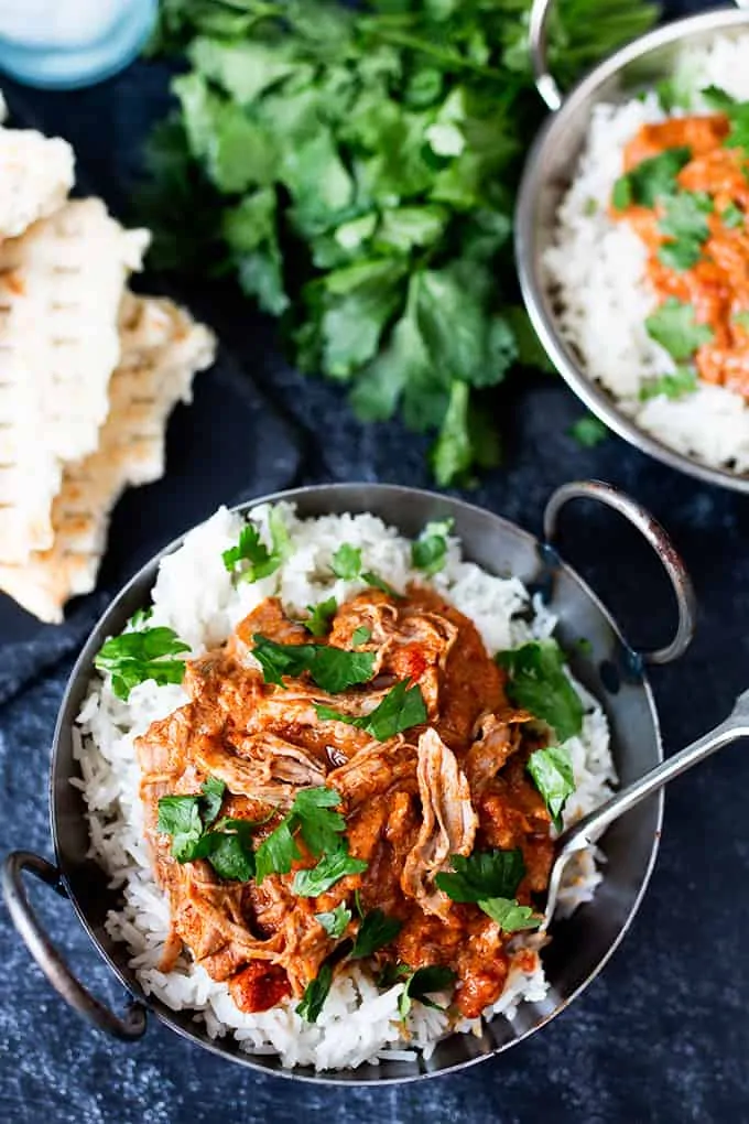 Slow cooked lamb curry in a blue bowl with rice.