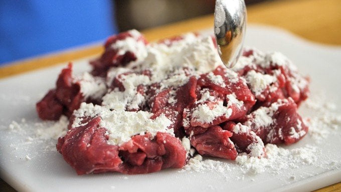Beef strips being coated in cornflour ready for frying