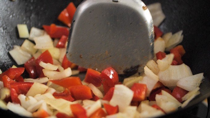 Peppers and onions frying in a wok