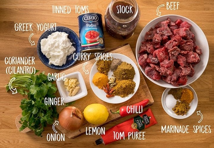 Ingredients for slow cooked lighter beef curry on a wooden table