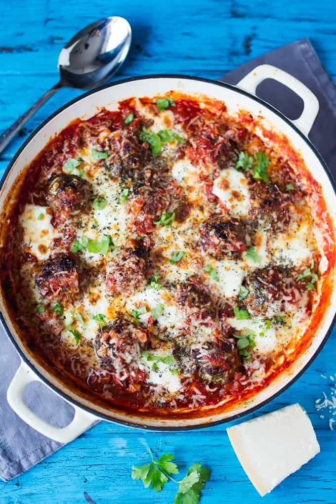 Ovehead shot of a pan full of hidden veg meatballs on a blue background