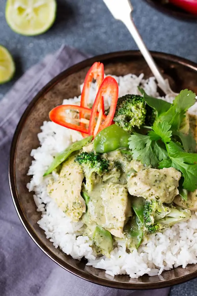 Close up overhead of Thai chicken curry with rice and chillis