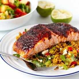 Spiced caramelised salmon served on a bed of savoury rice with feta and veggies. Colourful, healthy and delicious!