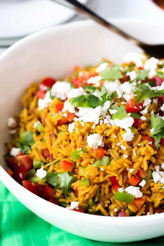 Spiced caramelised salmon served on a bed of savoury rice with feta and veggies. Colourful, healthy and delicious!