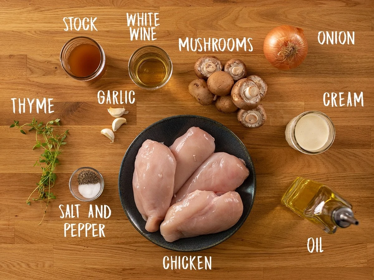 Ingredients for chicken in creamy white wine sauce on a wooden table