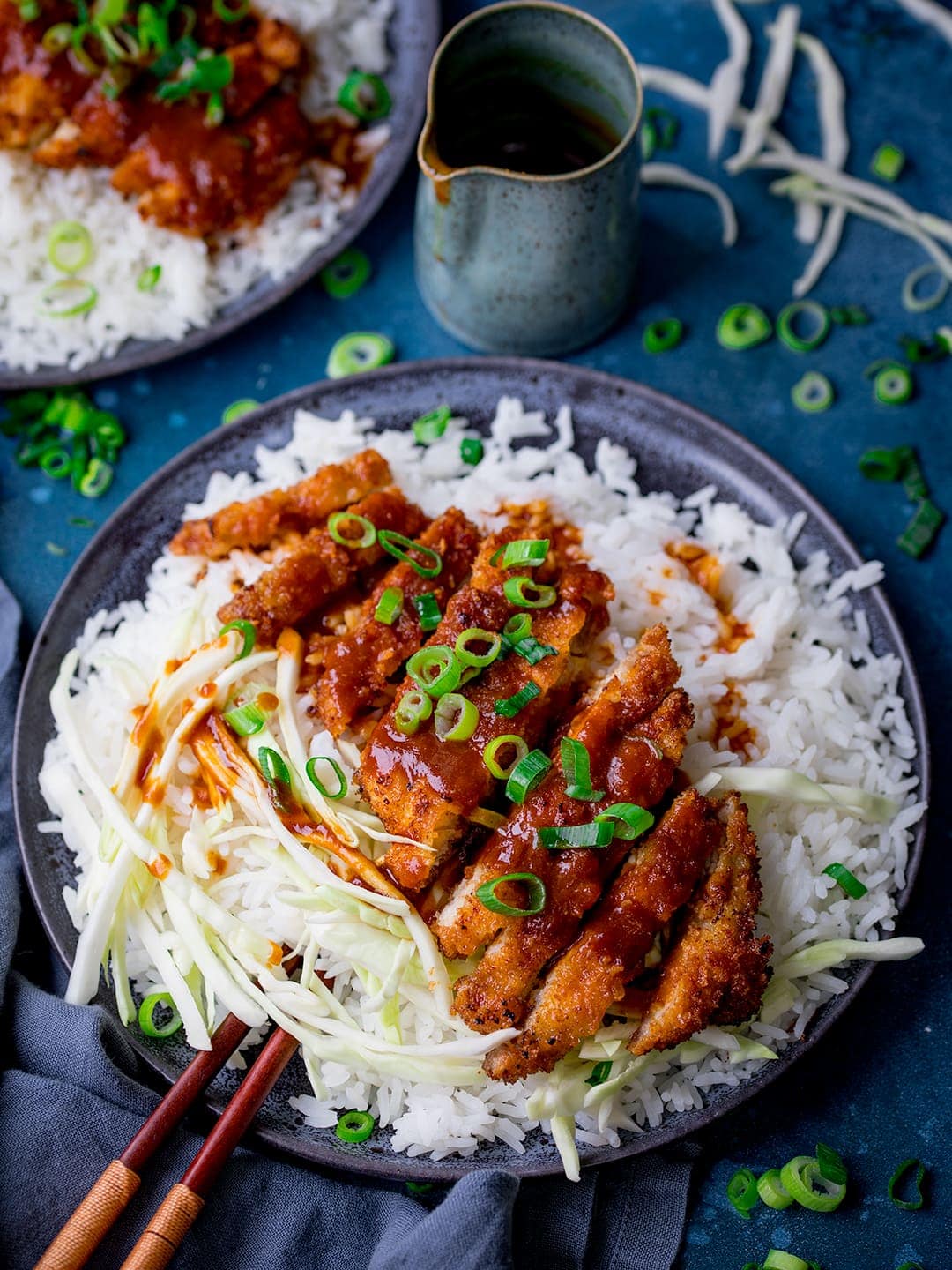 Tonkatsu pork curry on a dark plate with rice and cabbage