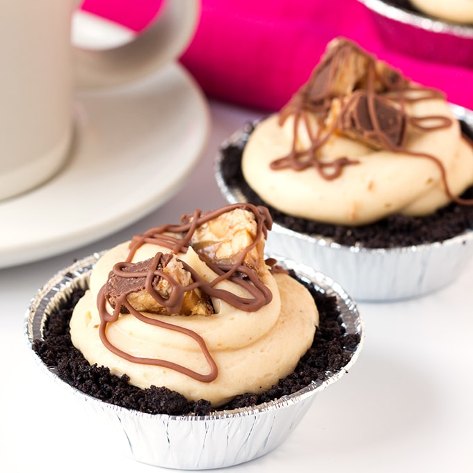 Mini Snickers Cheesecakes - with an Oreo base, peanut butter cheesecake and Snickers pieces. Totally addictive!