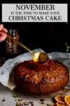 Cherry brandy being spooned onto fruit Christmas cake. Text overlay on the image.