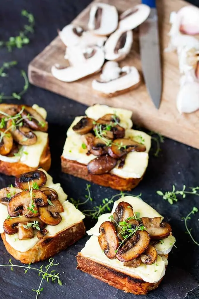 Garlic Mushroom and Brie Toast cut into squares with a sprig of thyme ontop