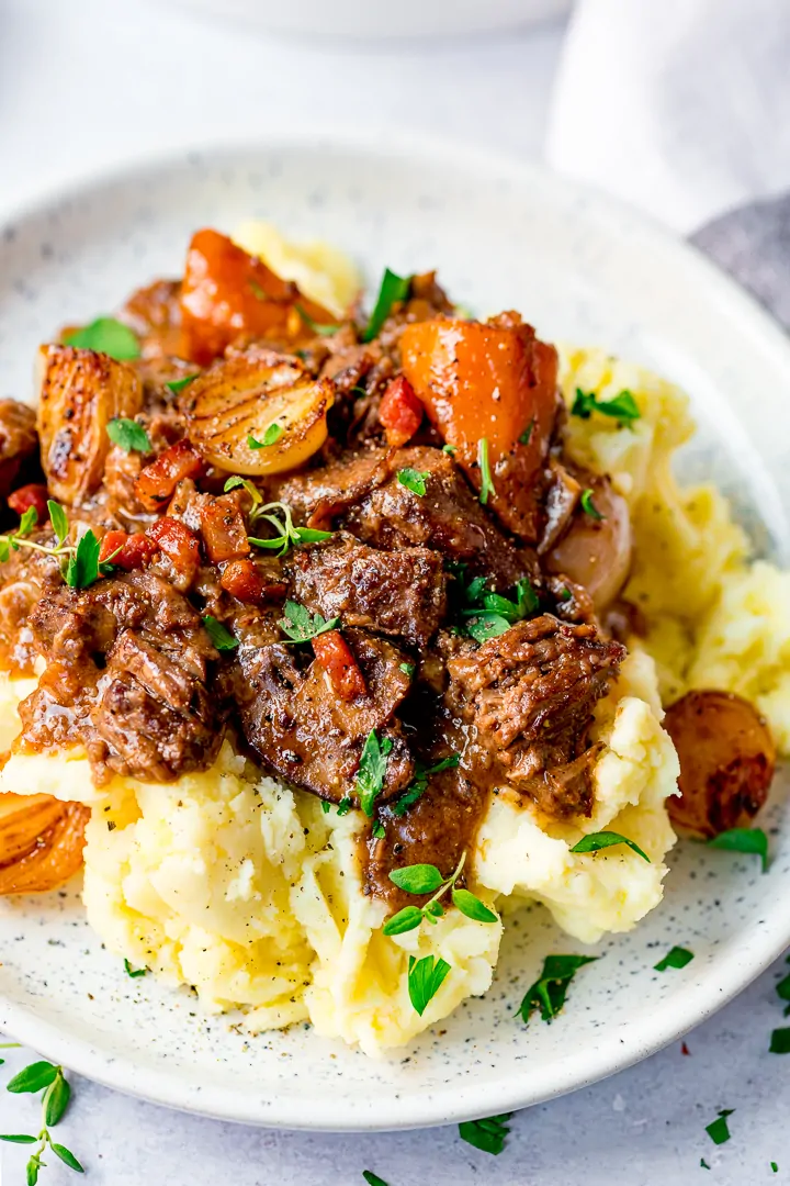 Beef Bourguignon with mashed potato on a white plate
