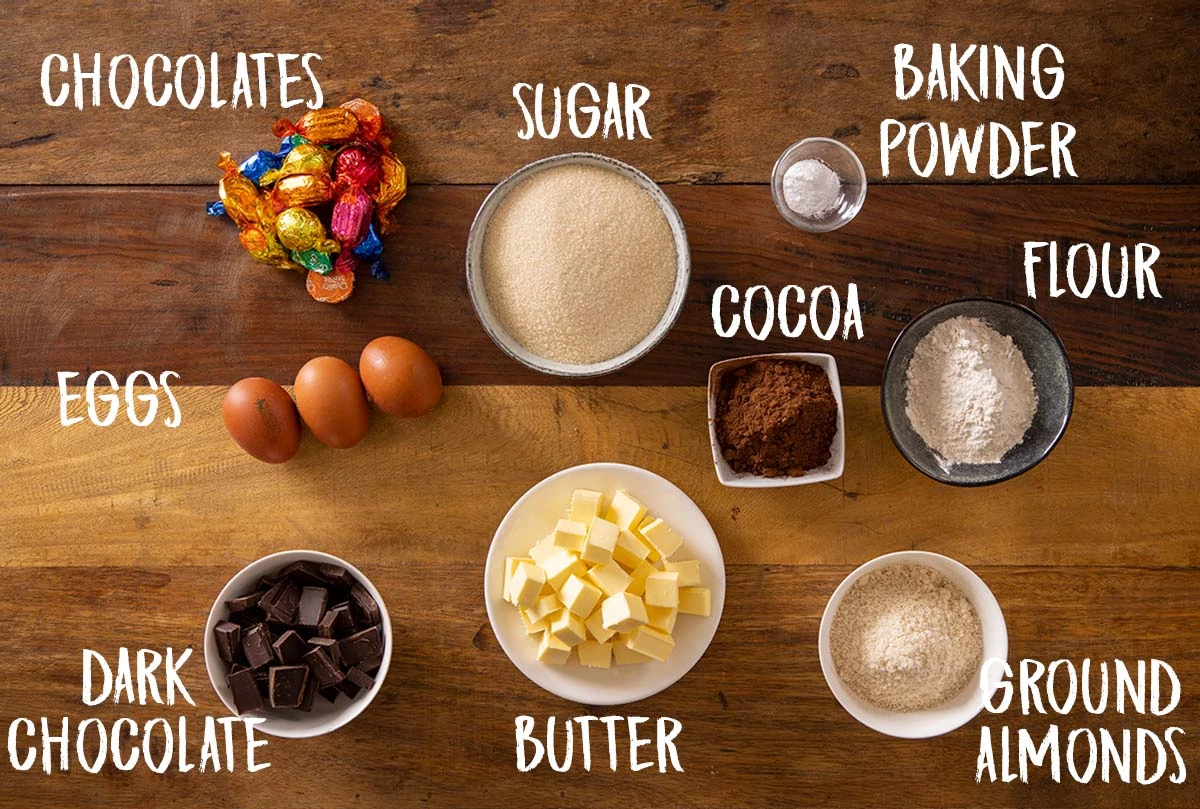 Overhead imaged of individual Ingredients for chcoclate brownies on a wooden board with labels.