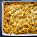 Overhead image of tuna pasta bake in a white dish topped with finely chopped parsley.