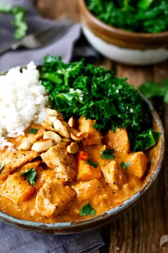 Close up photo of African Stew in a stone bowl with rice and kale