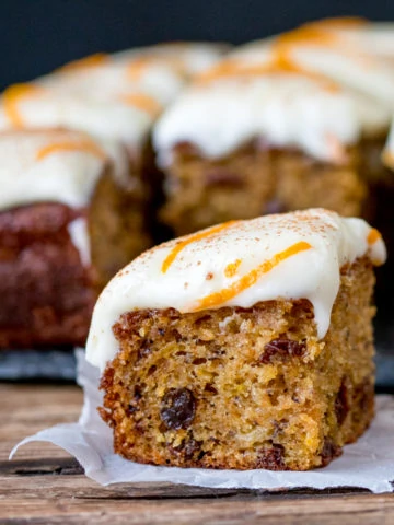 A fluffy moist carrot tray bake with orange infused raisins and zesty cream cheese frosting!