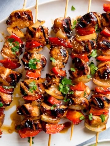 honey garlic chicken skewers on a white plate