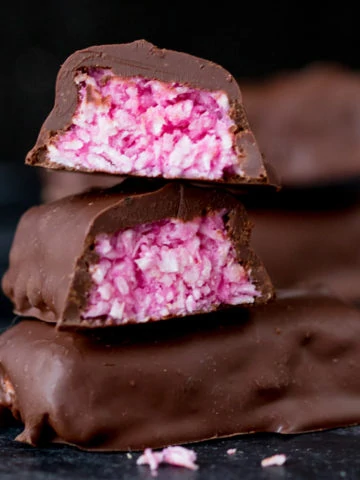 Raspberry Ruffle Bars - A vibrant coconut raspberry snack bar, covered in rich, dark chocolate.