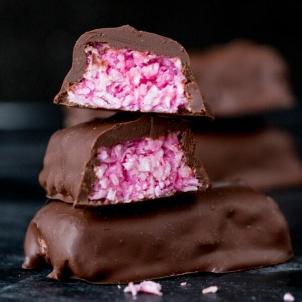 Raspberry Ruffle Bars - A vibrant coconut raspberry snack bar, covered in rich, dark chocolate.