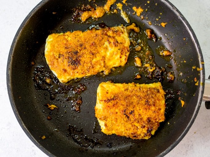 Thai fish fillets frying in a pan.