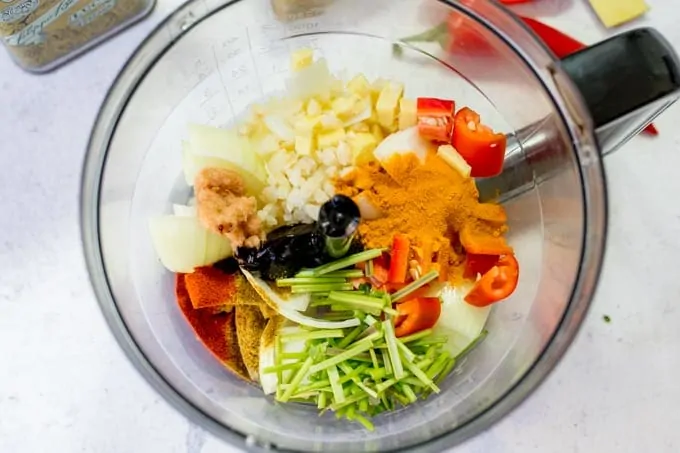 Ingredients in a mini blender for yellow Thai curry paste.