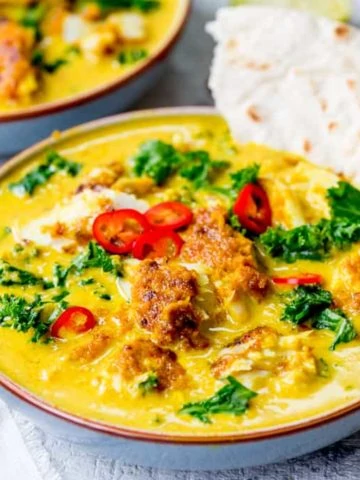 Square image of Thai fish yellow curry with kale.