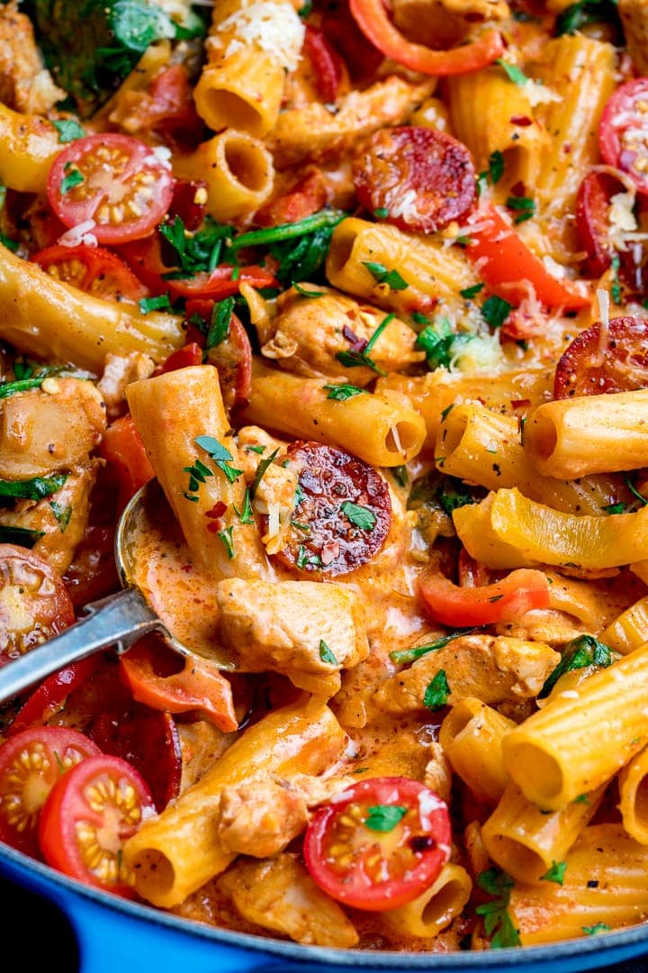 Close up image of Cajun chicken pasta with a spoonful being taken.
