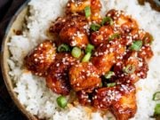 Crispy Sesame Chicken on a bed of rice in a stone bowl