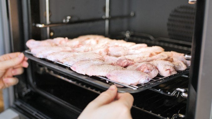 Raw chicken wings on a baking tray, about to go into the oven