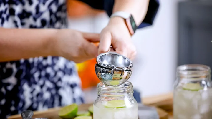 Squeezing lime into a mason jar for a cocktail