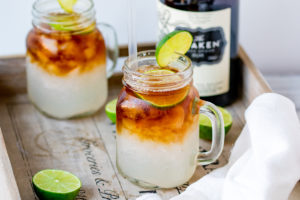 Wide image of dark and stormy cocktail in a mason jar glass