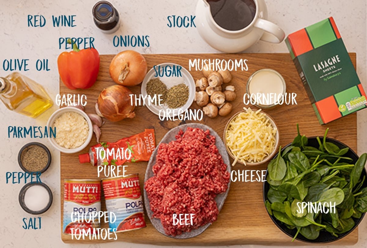 Ingredients for lasagne soup on a wooden board on a light background.