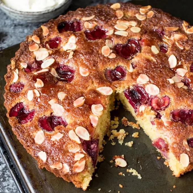 A fluffy Cherry and Almond Cake with fresh cherries and dollops of jam. So tasty and gluten free too!