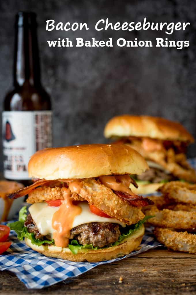 Bacon Cheeseburger with Baked Parmesan Onions Rings on a wooden board with a bottle of beer in the background