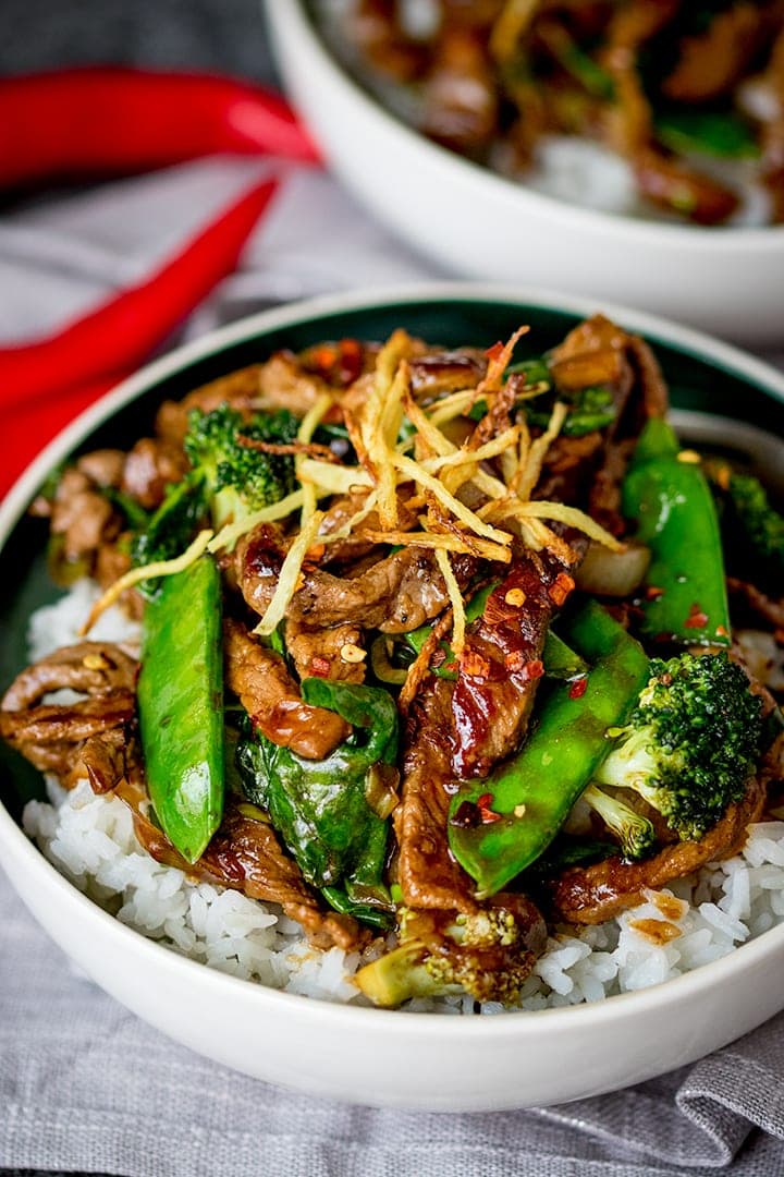 Ginger beef stir fry in a bowl with broccoli and rice