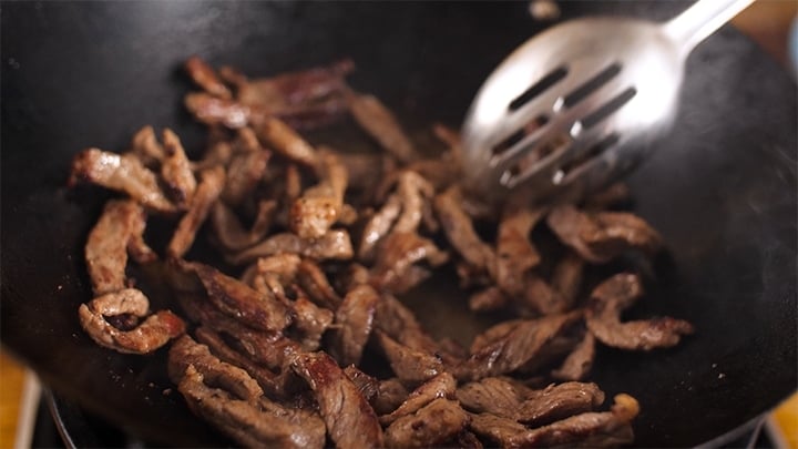 Strips of steak being fried in a wok