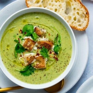 Broccoli Cheese Soup croutons and baby leaves in a white bowl