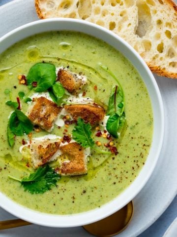 Broccoli Cheese Soup croutons and baby leaves in a white bowl