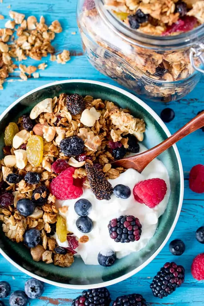 Bowl of homemade granola with fresh berries and yogurt in a bowl